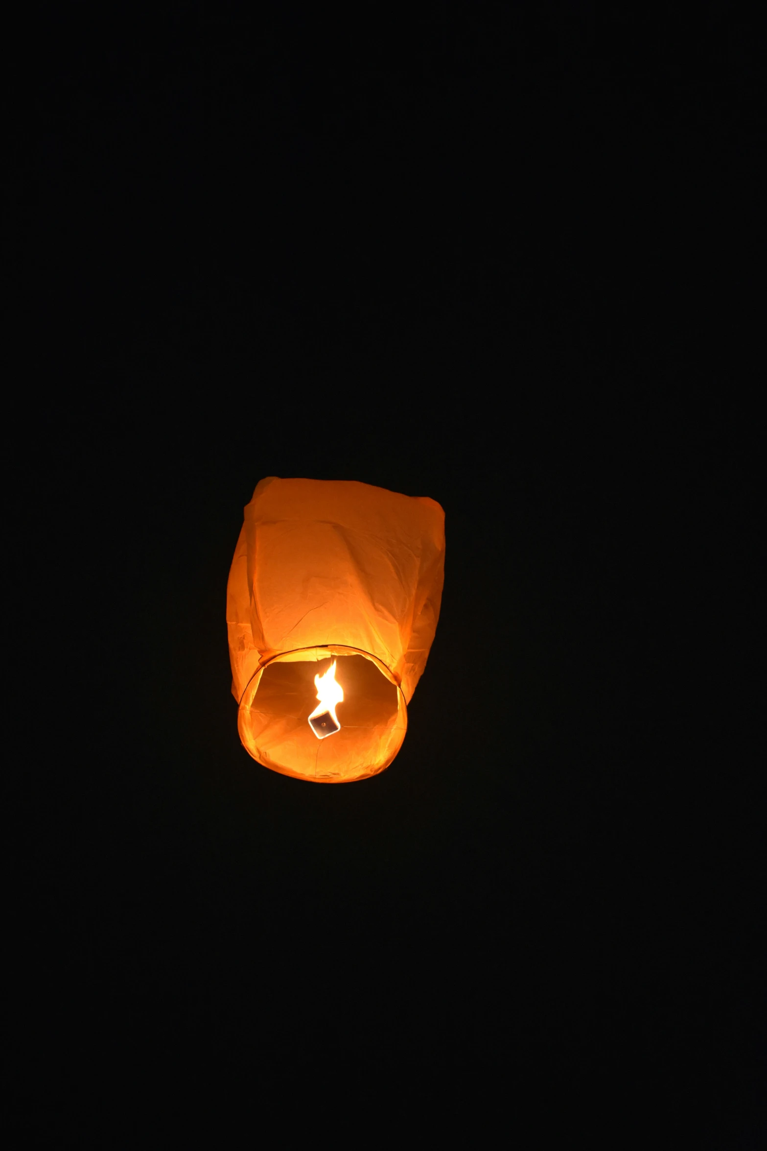 an orange lantern floating in the air with a star lit inside