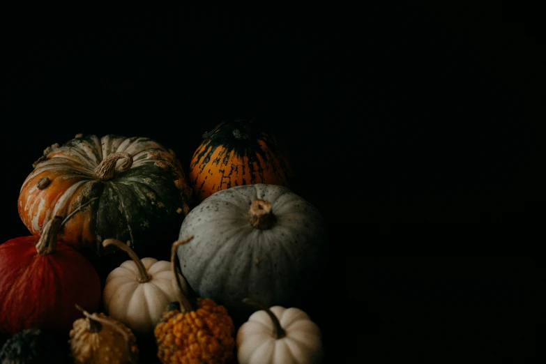 a grouping of pumpkins sitting on top of a table