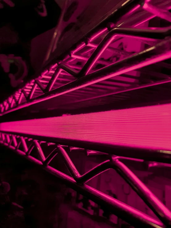 a close - up of metal beams, lit with purple light