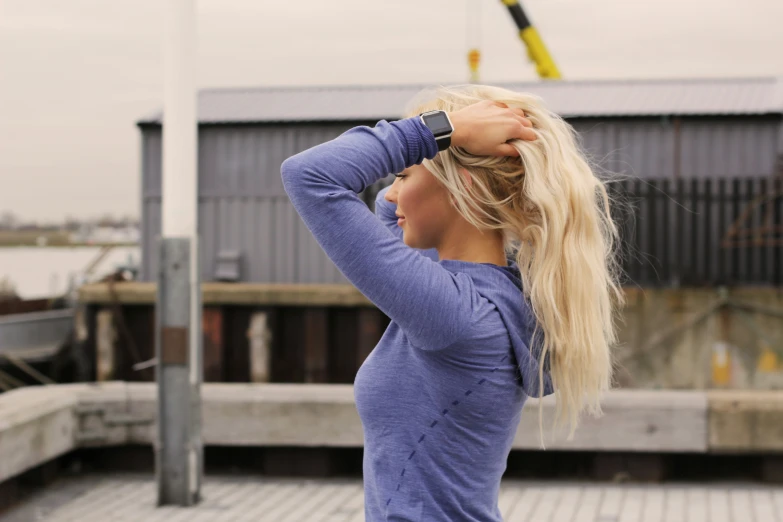 a woman with long blond hair holding her back