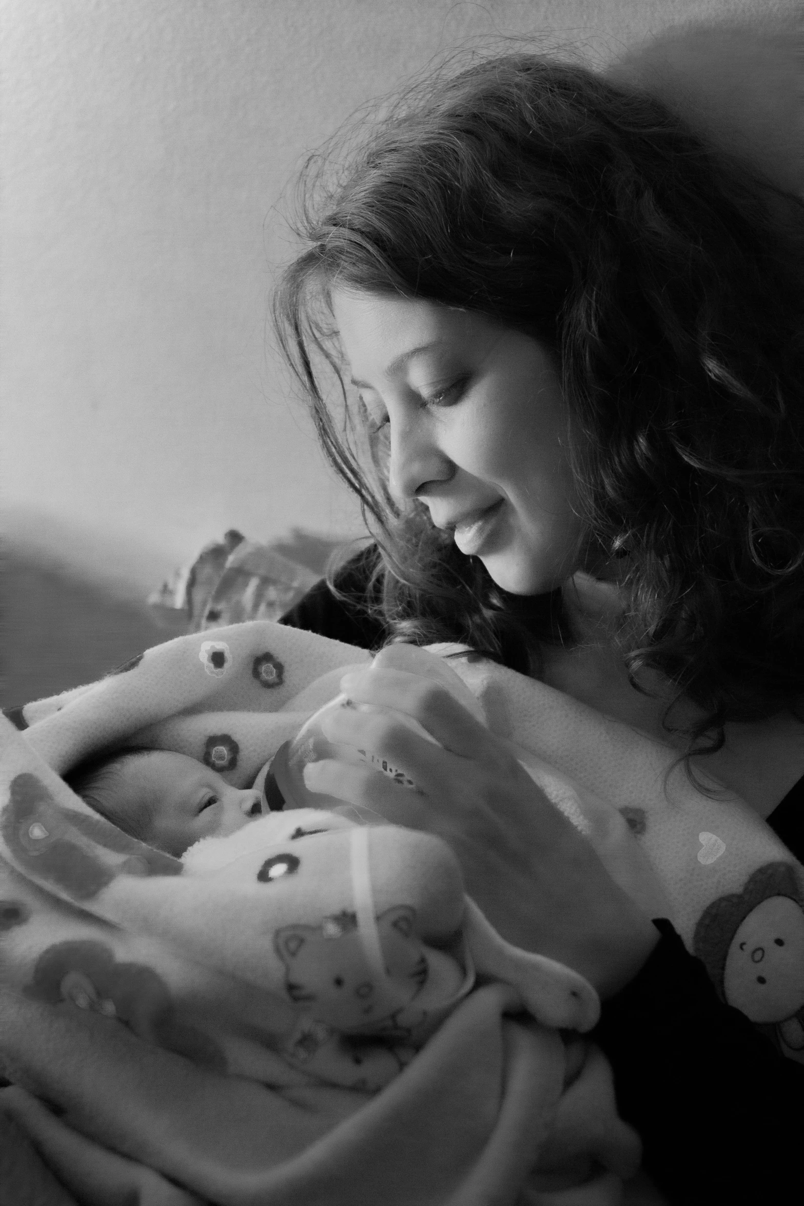 woman holding the baby in her arms looking down