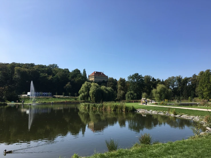 a pond with a house in the background