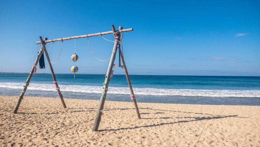 a set of swings that are on the beach