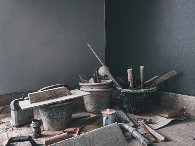 several buckets and tools sitting next to each other on a wooden floor