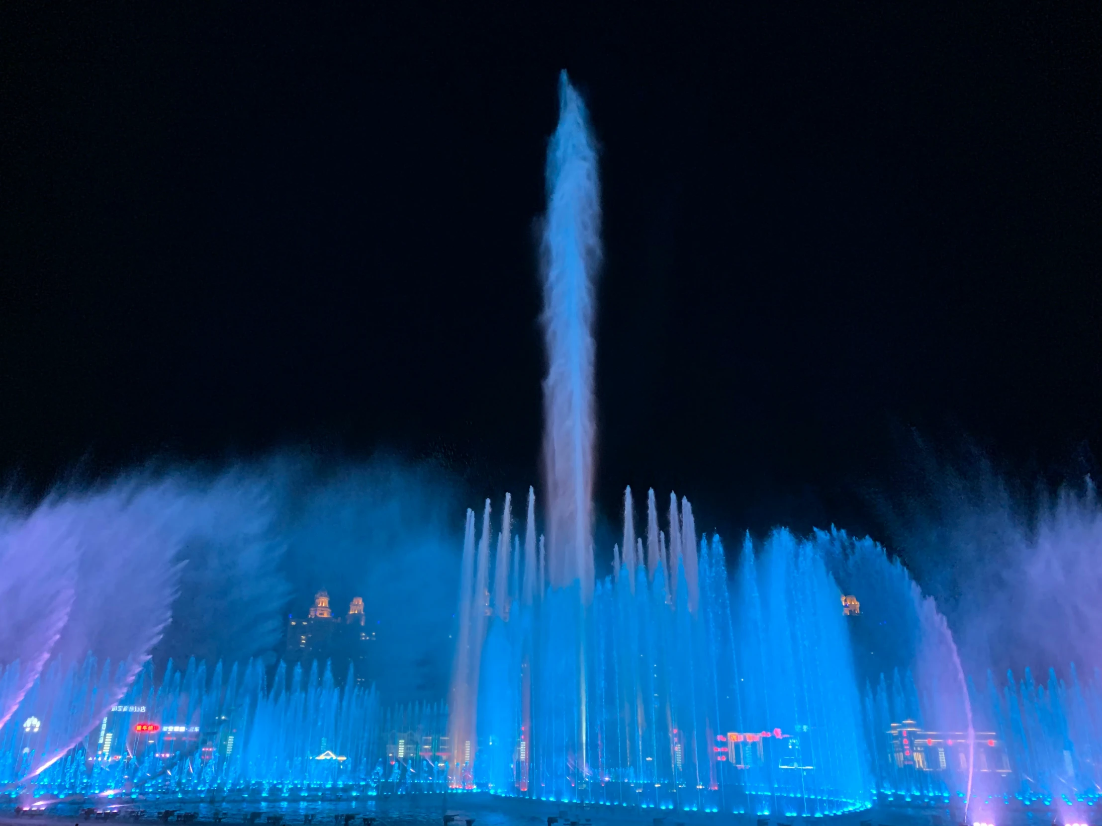 water show in large city area with blue light and water spout