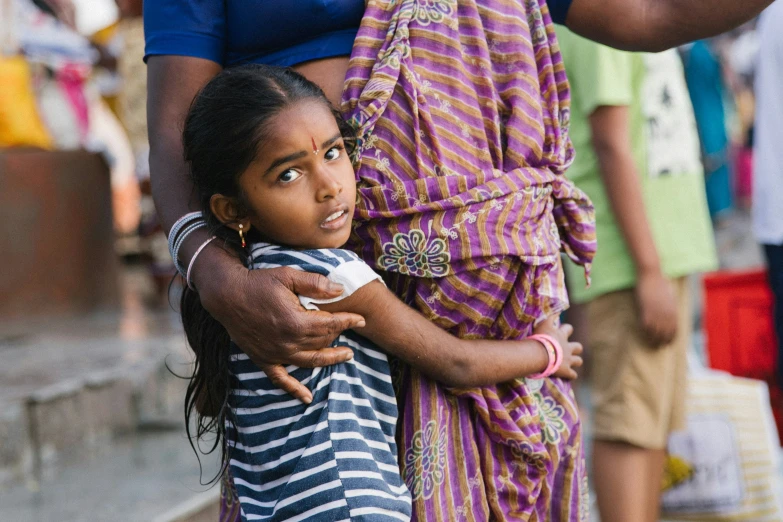 a woman carrying a small girl in her arms