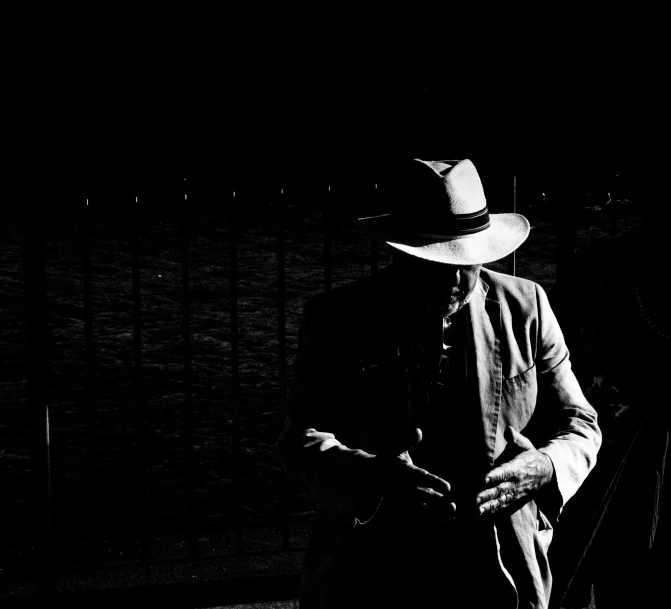 black and white image of man with a cowboy hat and guitar