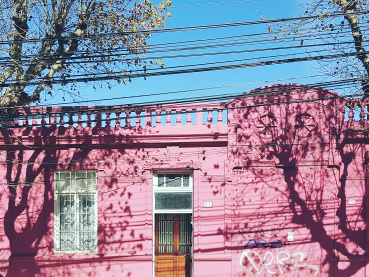 a pink building that has graffiti on the side of it