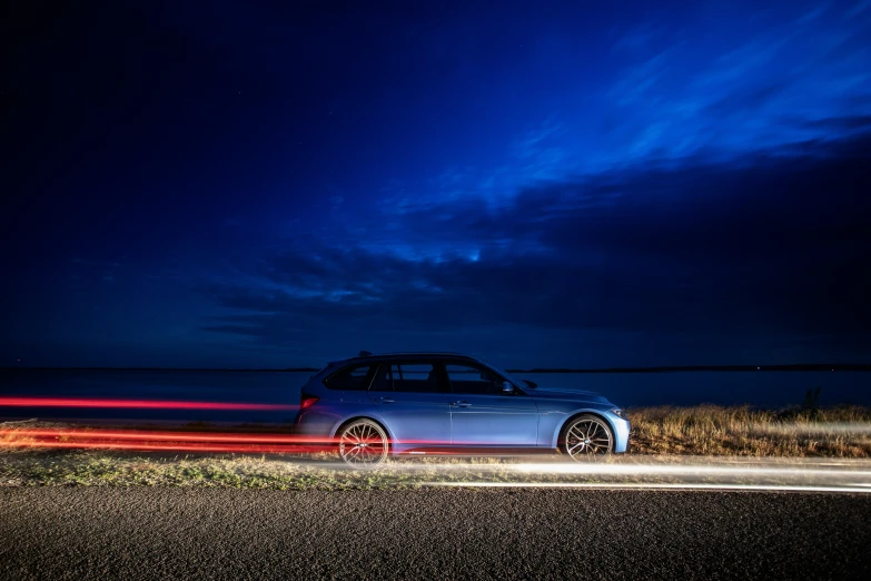 a silver car parked on the side of the road at night