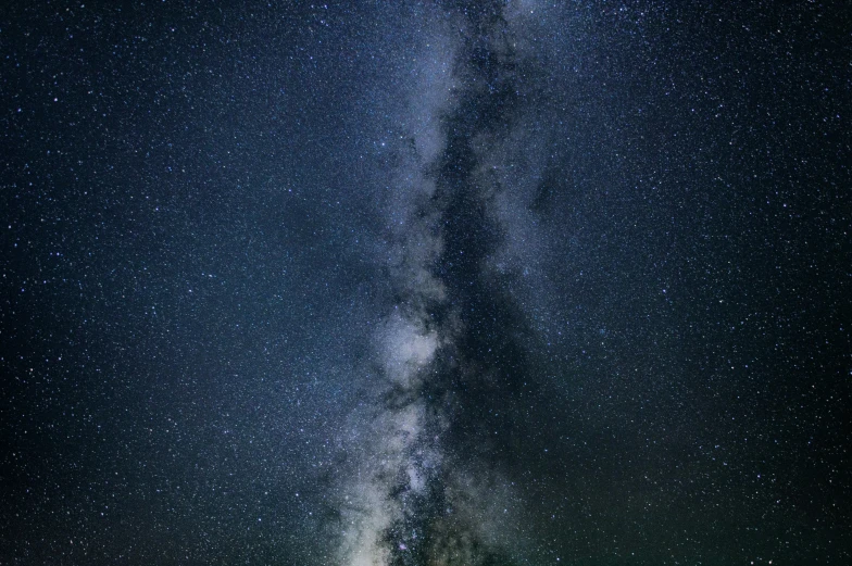 a field covered in green grass under a blue night sky