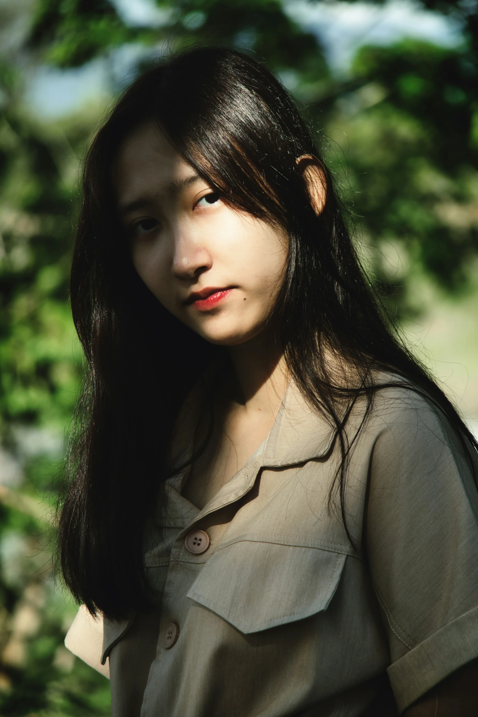 a woman with long dark hair is standing near the grass