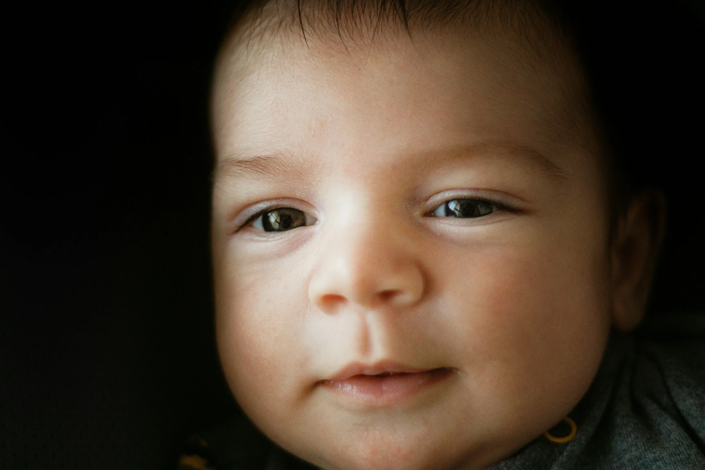 a baby has blue eyes as it looks at soing
