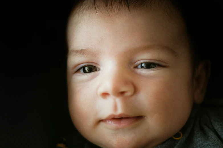 a baby has blue eyes as it looks at soing