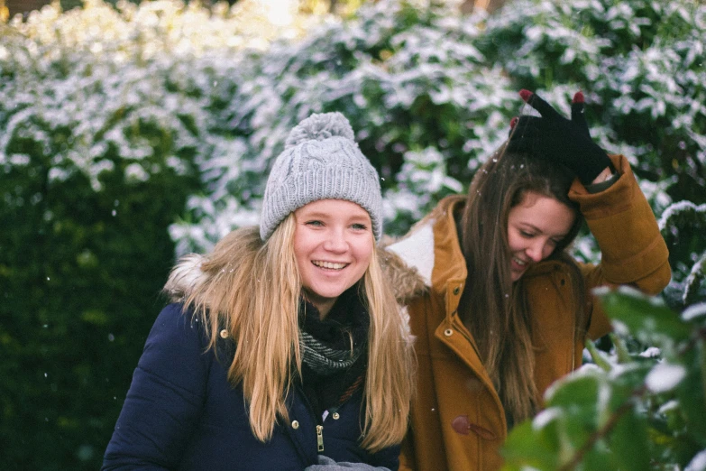 two young women smiling outside in the snow