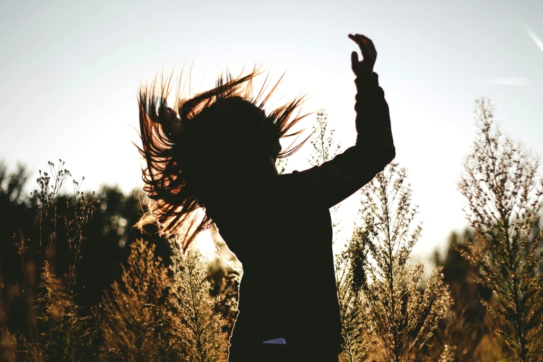 woman's hair flowing into the air at sunset
