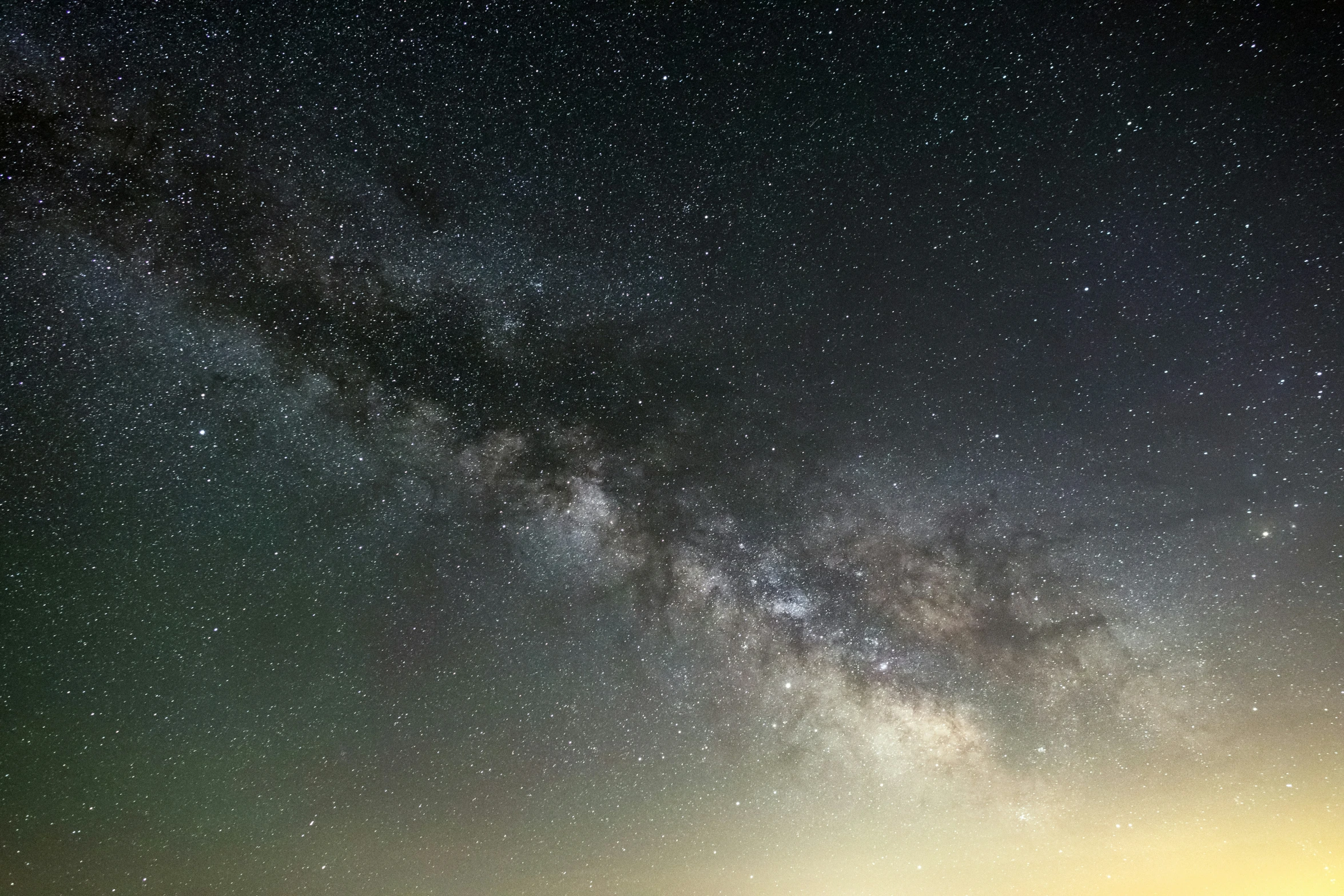 a field of grass with people under a night sky