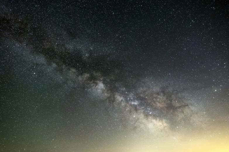 a field of grass with people under a night sky