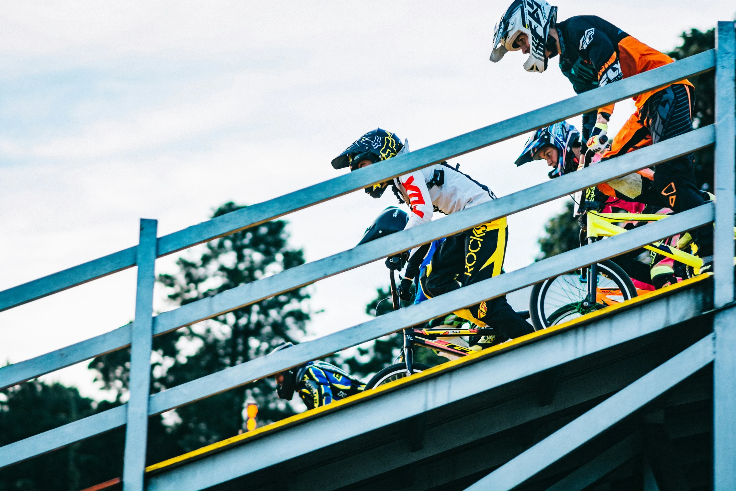 two people on bicycles riding on a rail