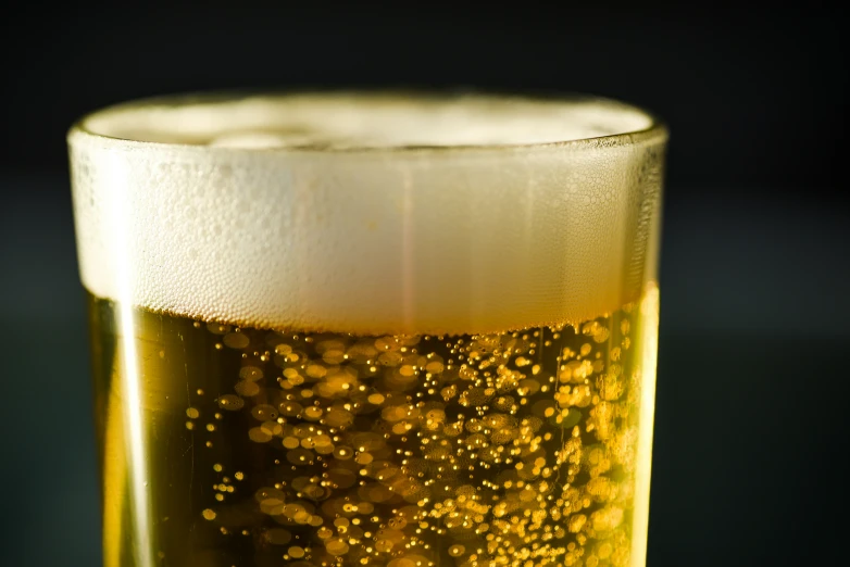 a beer glass filled with liquid and gold flecks