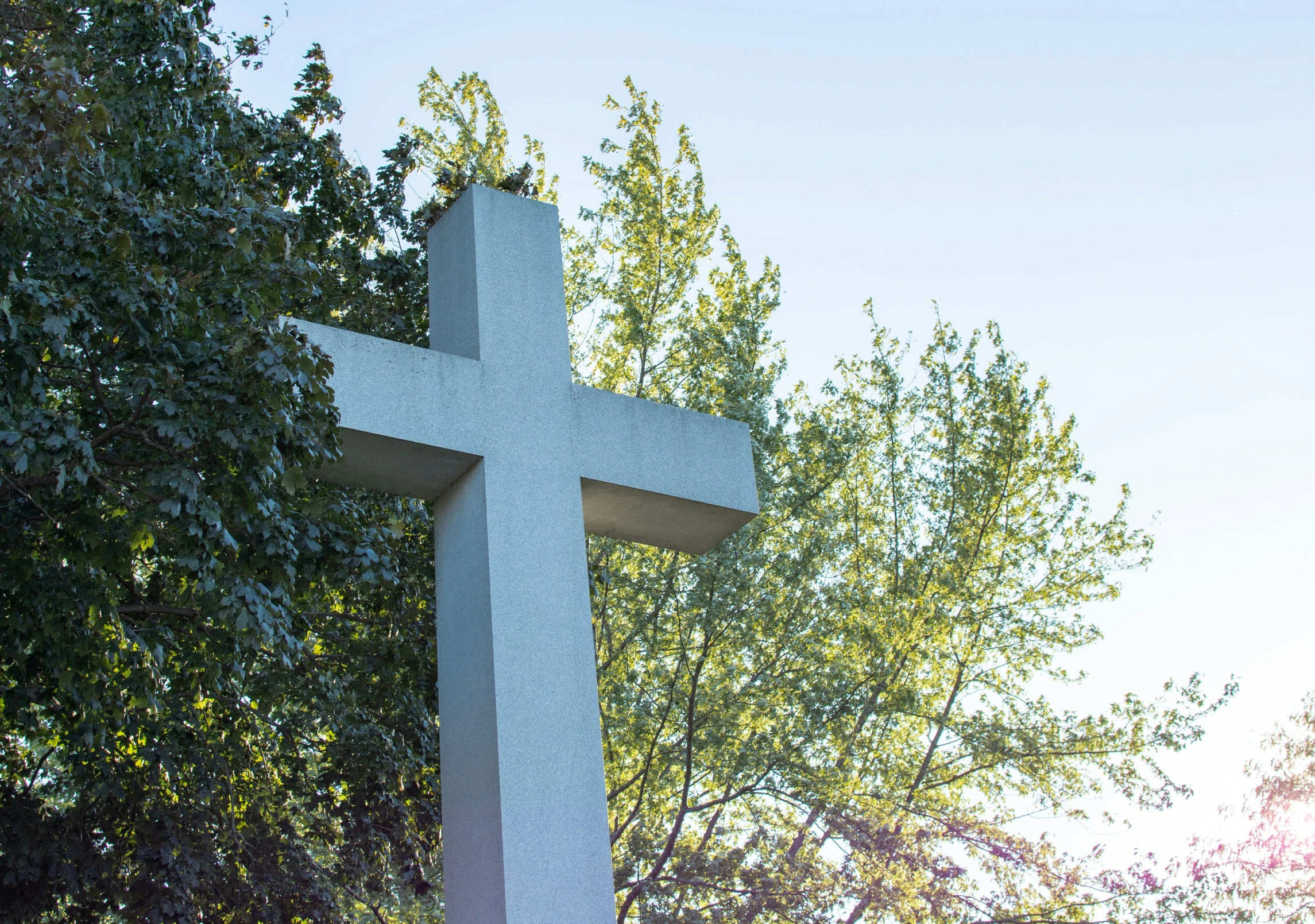 a gray cross that is in the grass