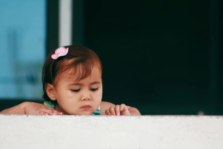 an adorable little girl looking at soing on her fingers