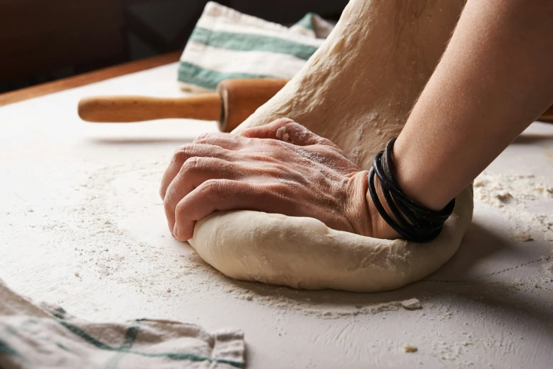 the person is putting soing on the top of the dough