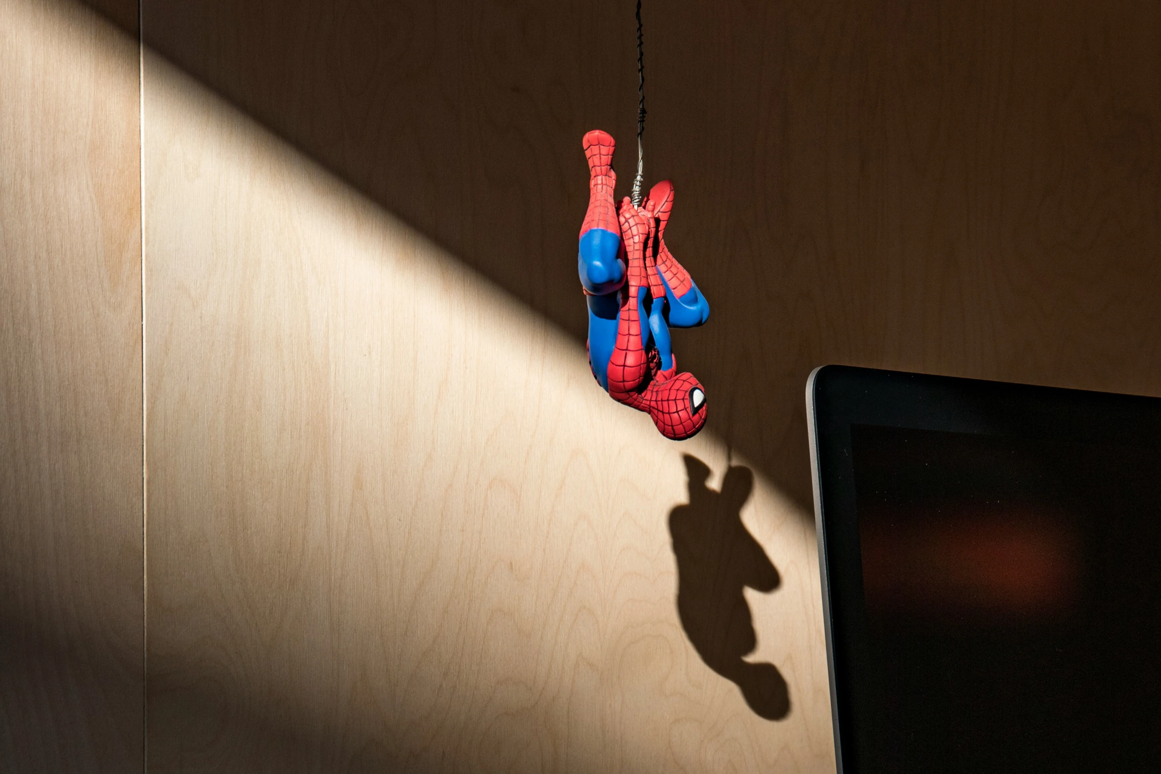 a small toy spider man is shown hanging on the wall