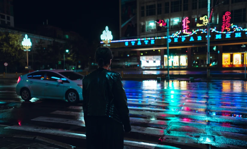 a man looking at some christmas lights on the side of a city street