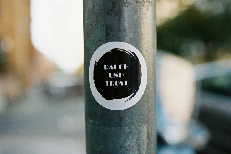 the sticker is on the post outside by the bus stop