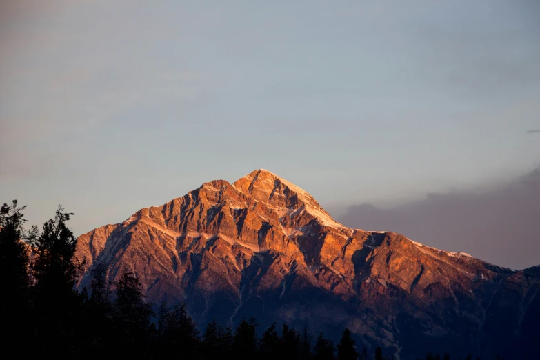 a mountain is seen with some clouds in the background