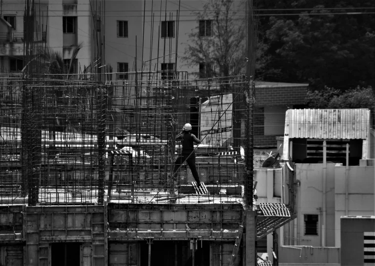 the man is standing on the top of the building under construction