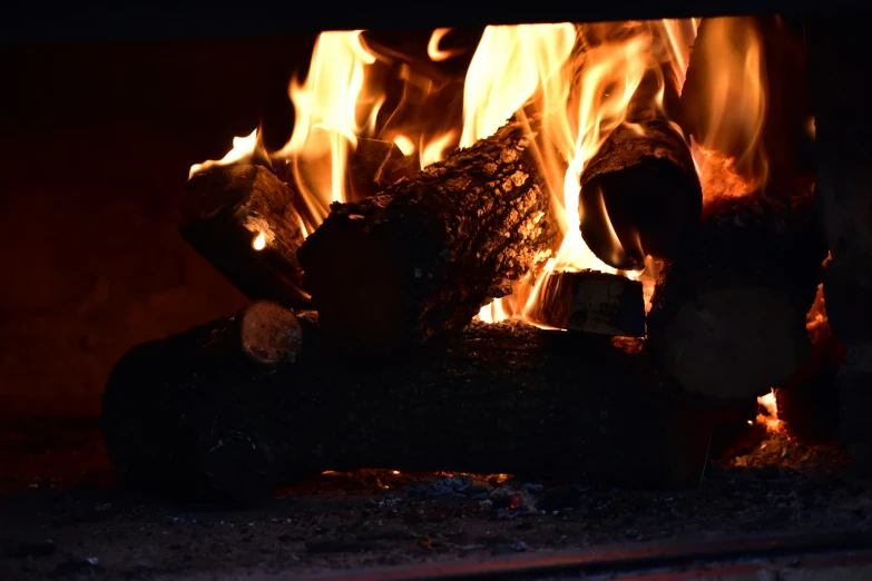 the fire blazing on the wood in the fireplace