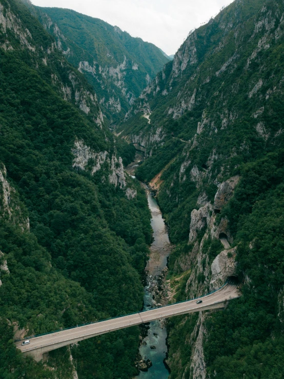 a bridge over a river with mountains behind it
