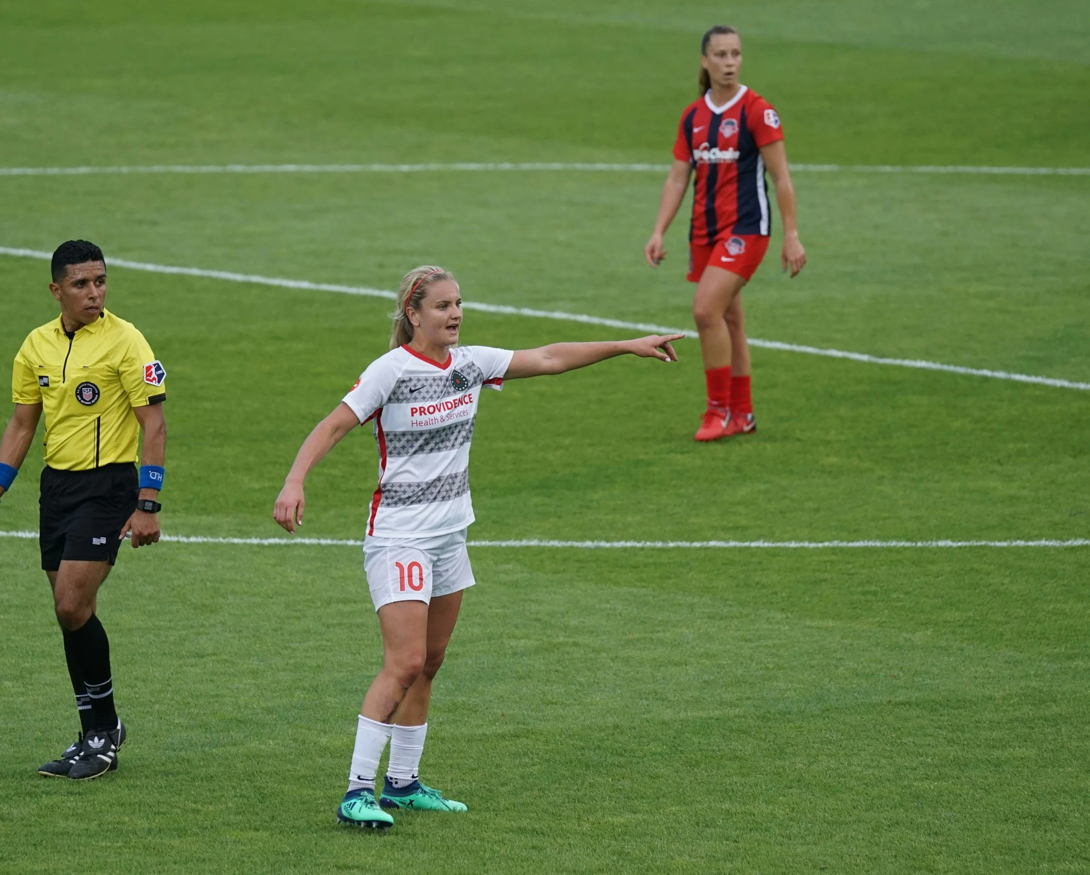 two soccer players standing on a field, one pointing and the other standing behind