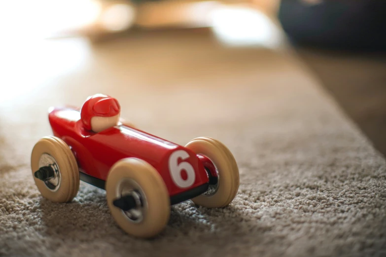 a toy red race car on the carpet