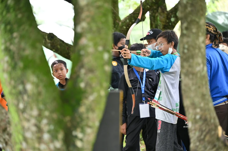 people with sports equipment looking through trees in the woods