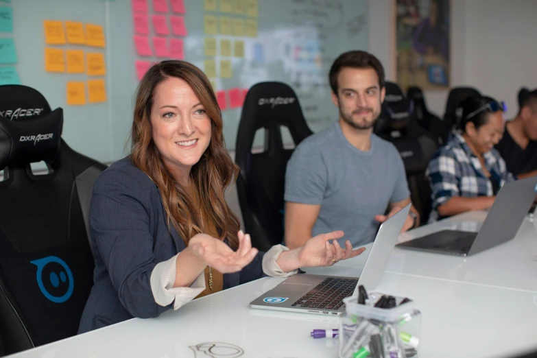 two women and a man with laptops on their laps in a group