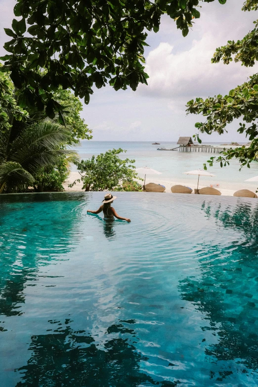 person floating in the water on a board under trees