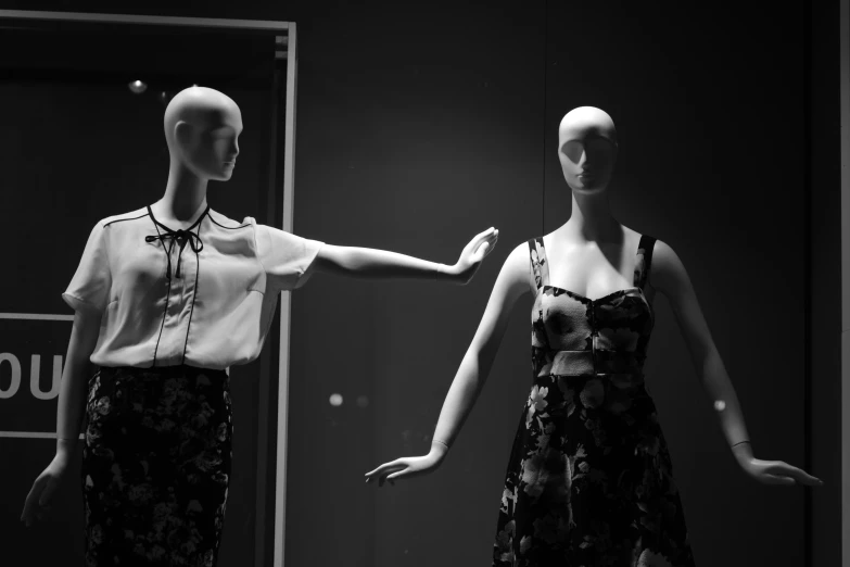 mannequins are posed in front of a mirror
