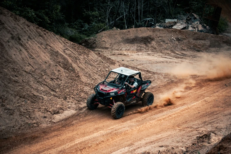 an atv traveling through some dirt near mountains