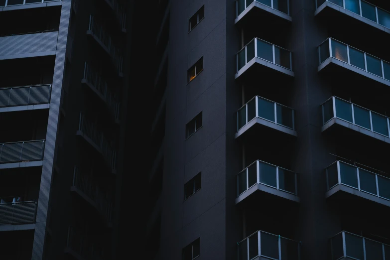 two buildings with balconies and windows at night