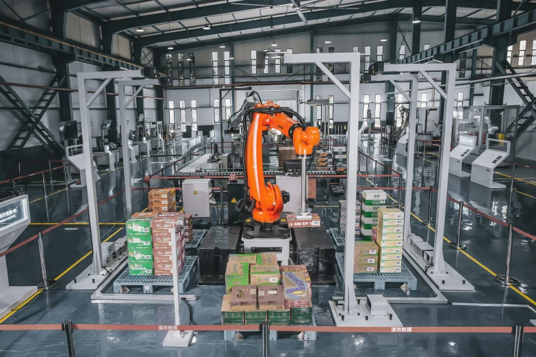 a large industrial machine and some boxes and orange robots