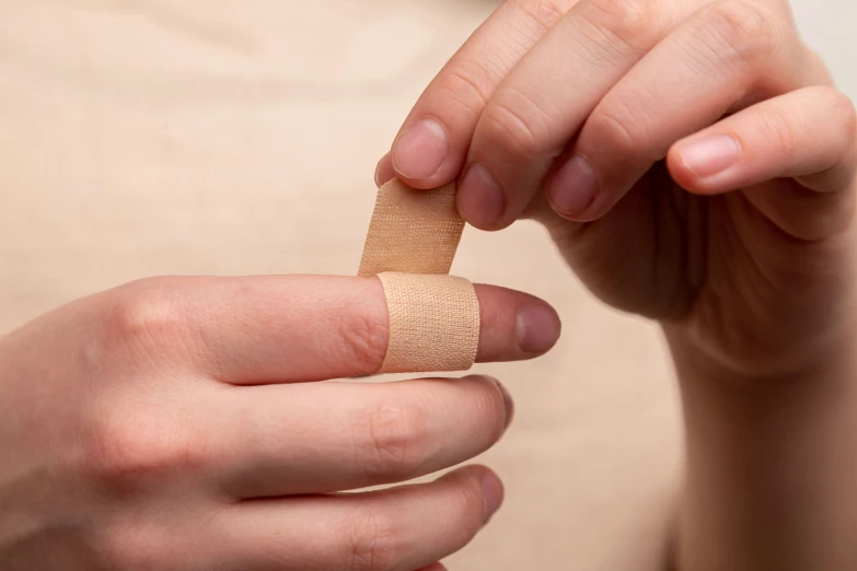 the person is wrapping his arm with a tape