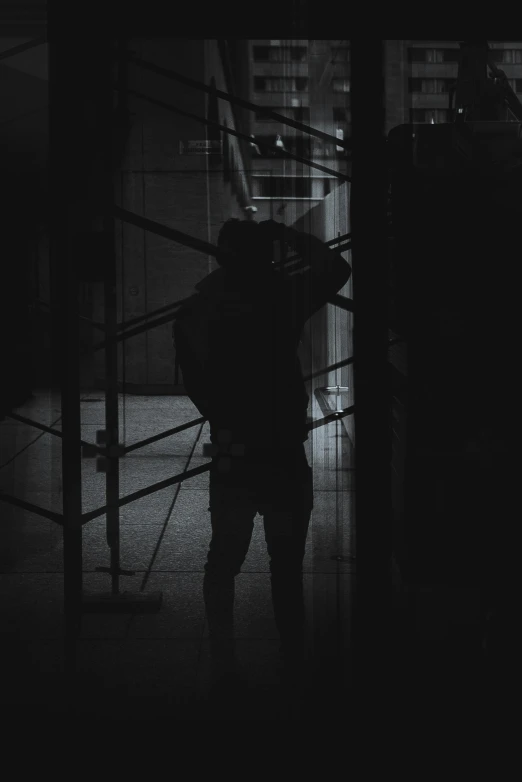 a silhouette of a man with a hat in the dark