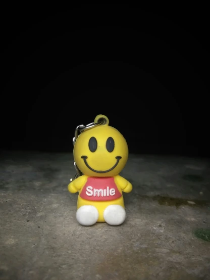 a little smiley face keyring with a smile on it