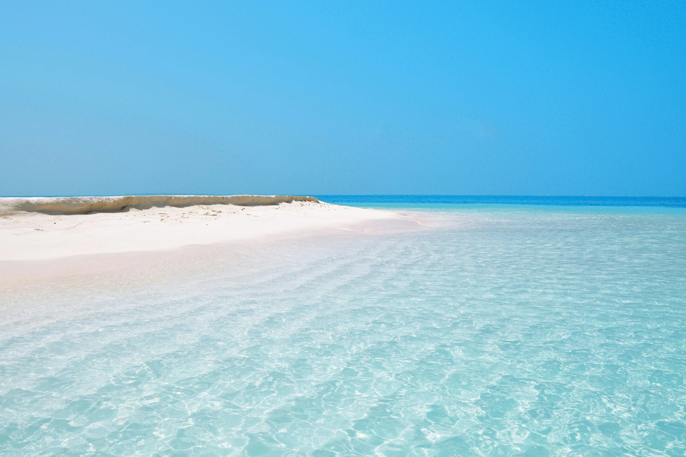 there is a small sandy beach with blue water in the distance