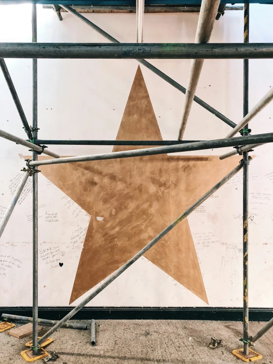 an image of a large brown star under scaffolding