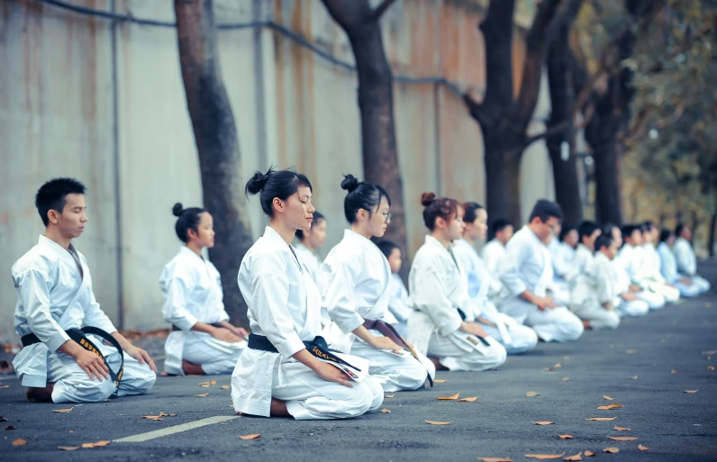 people in white are sitting on the ground