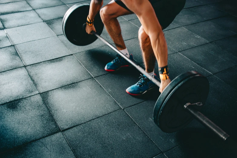 a person standing with their legs on the barbells