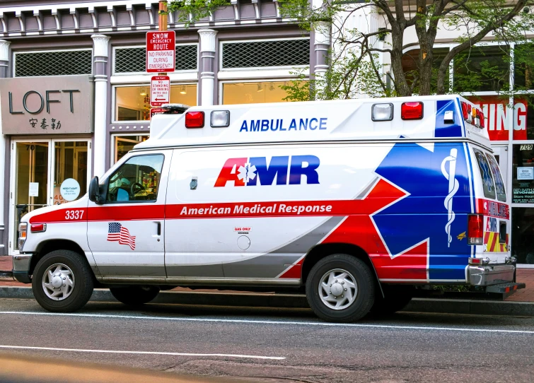 an ambulance sits parked on the side of the street